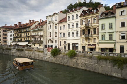 A boat sailing the Ljubljanica and a few of facades