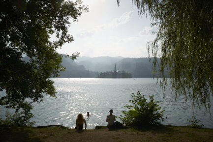 Lake Bled island framed with leaves and branches