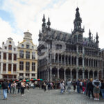 Horizontal photograph of the Maison du Roi de Bruxelles with many people in the Grand Place of Brussels